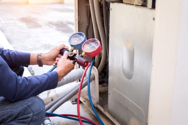 Technician checking AC unit gauges.